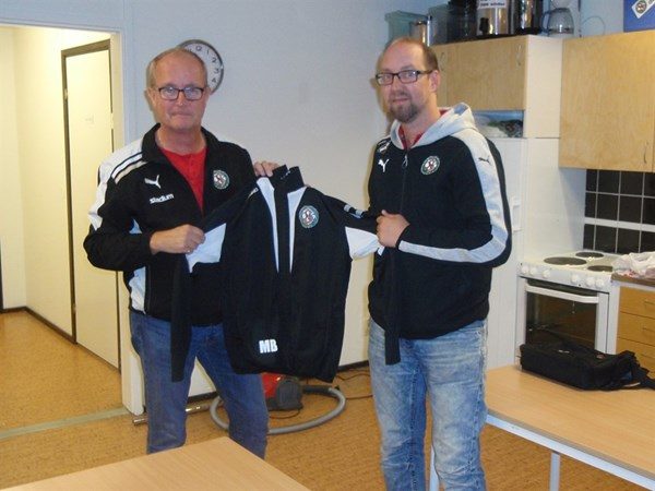 ÖSK Söders Tommy Sandberg kollar passformen på Mikael Bjälkefors nya tränarjacka. Den kommer nog att sitta bra.